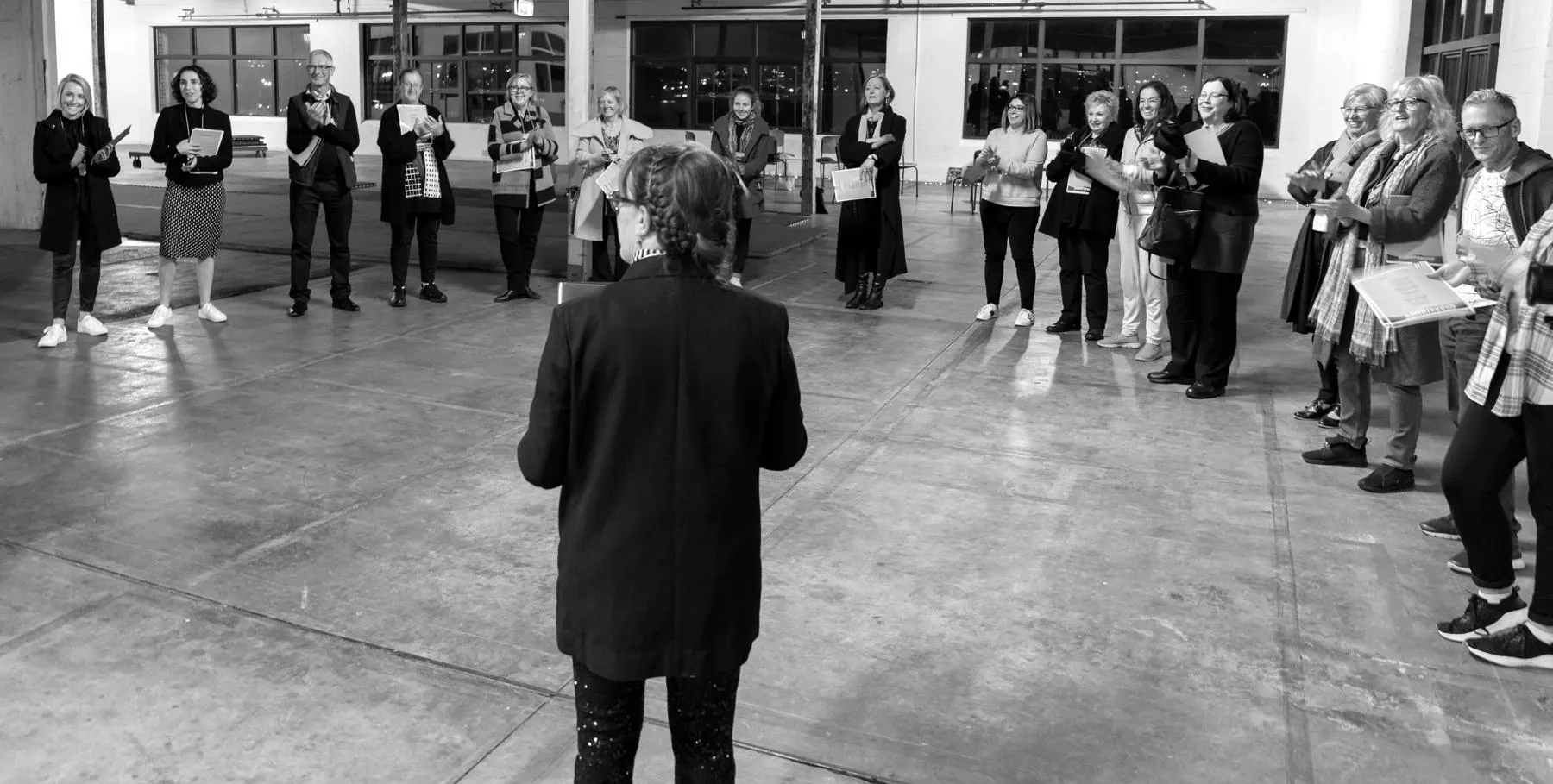 Ruth leading a warm-up with a circle of participants in a warehouse studio