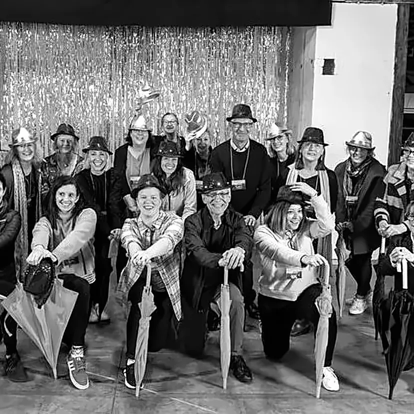 A large group celebrating in costume after their performance