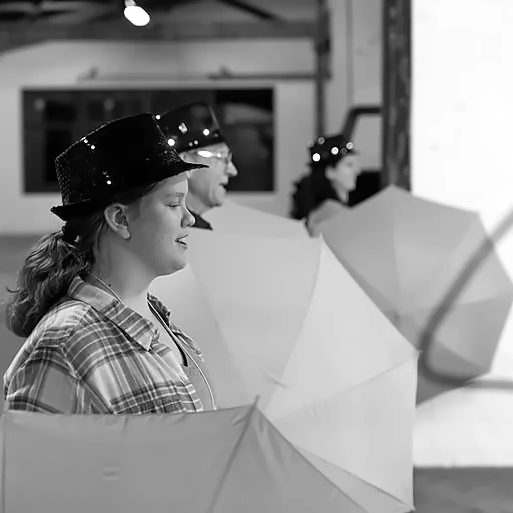 A participant in a light-up hat surrounded by umbrellas