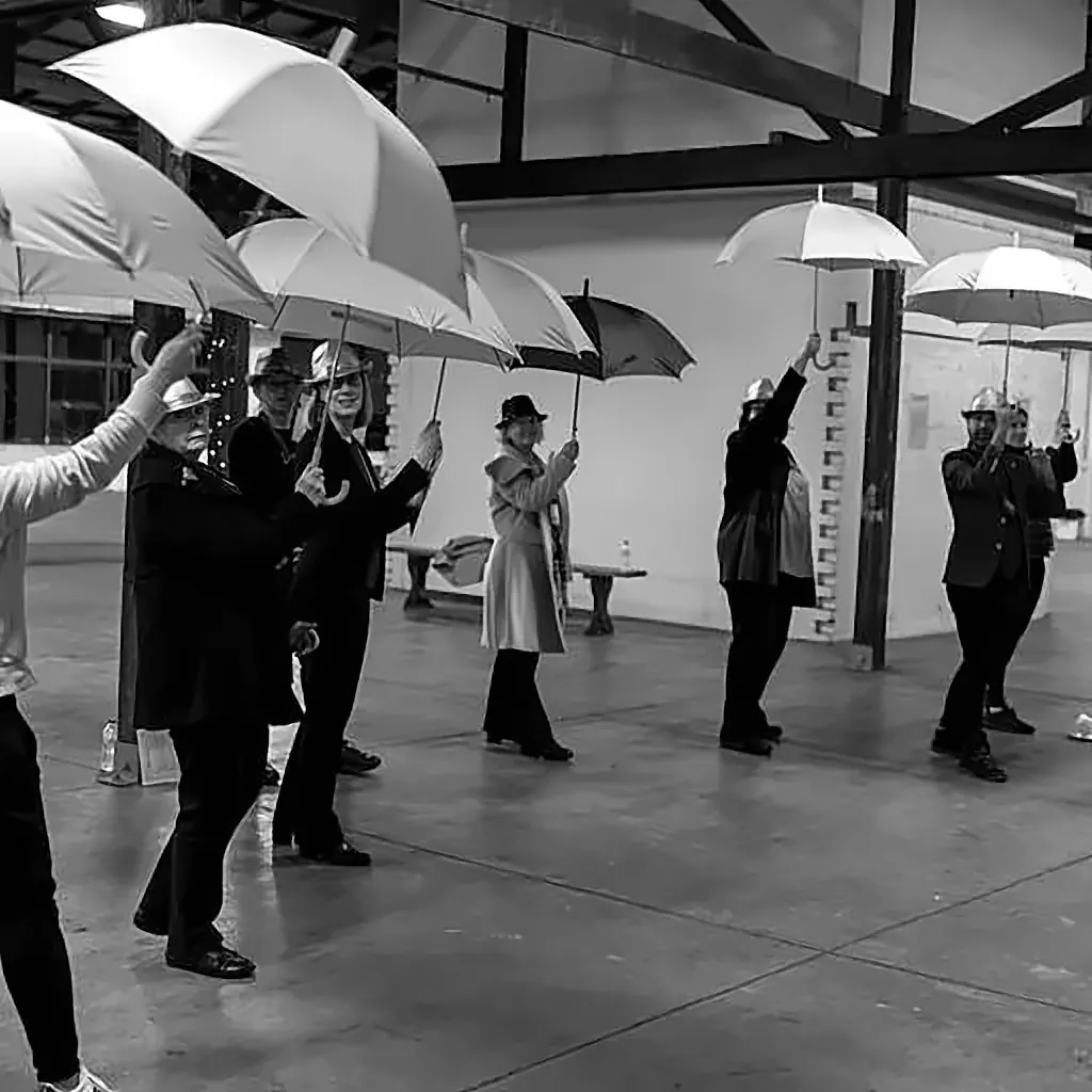Participants raising umbrellas during a routine